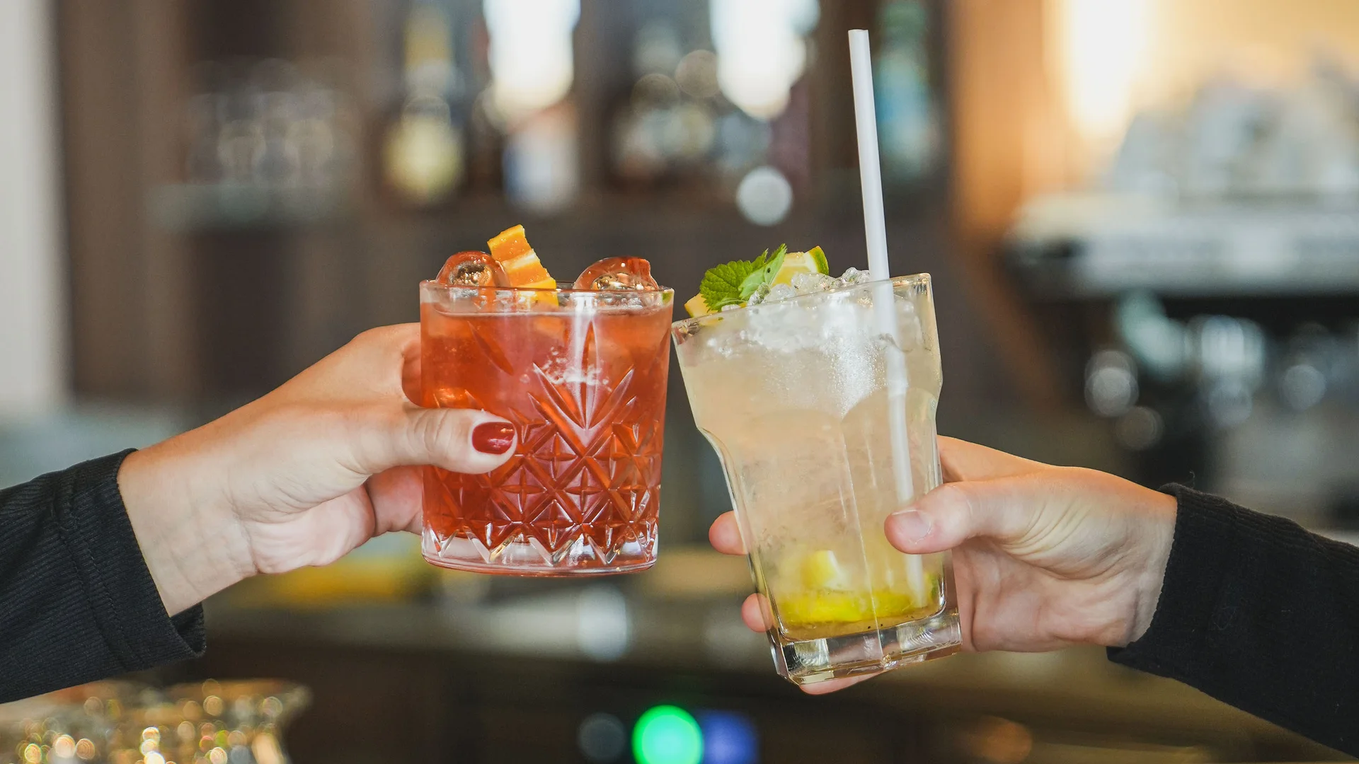 Impressionen in #echtzeit Zwei Hände stoßen mit Cocktails in einer Bar an