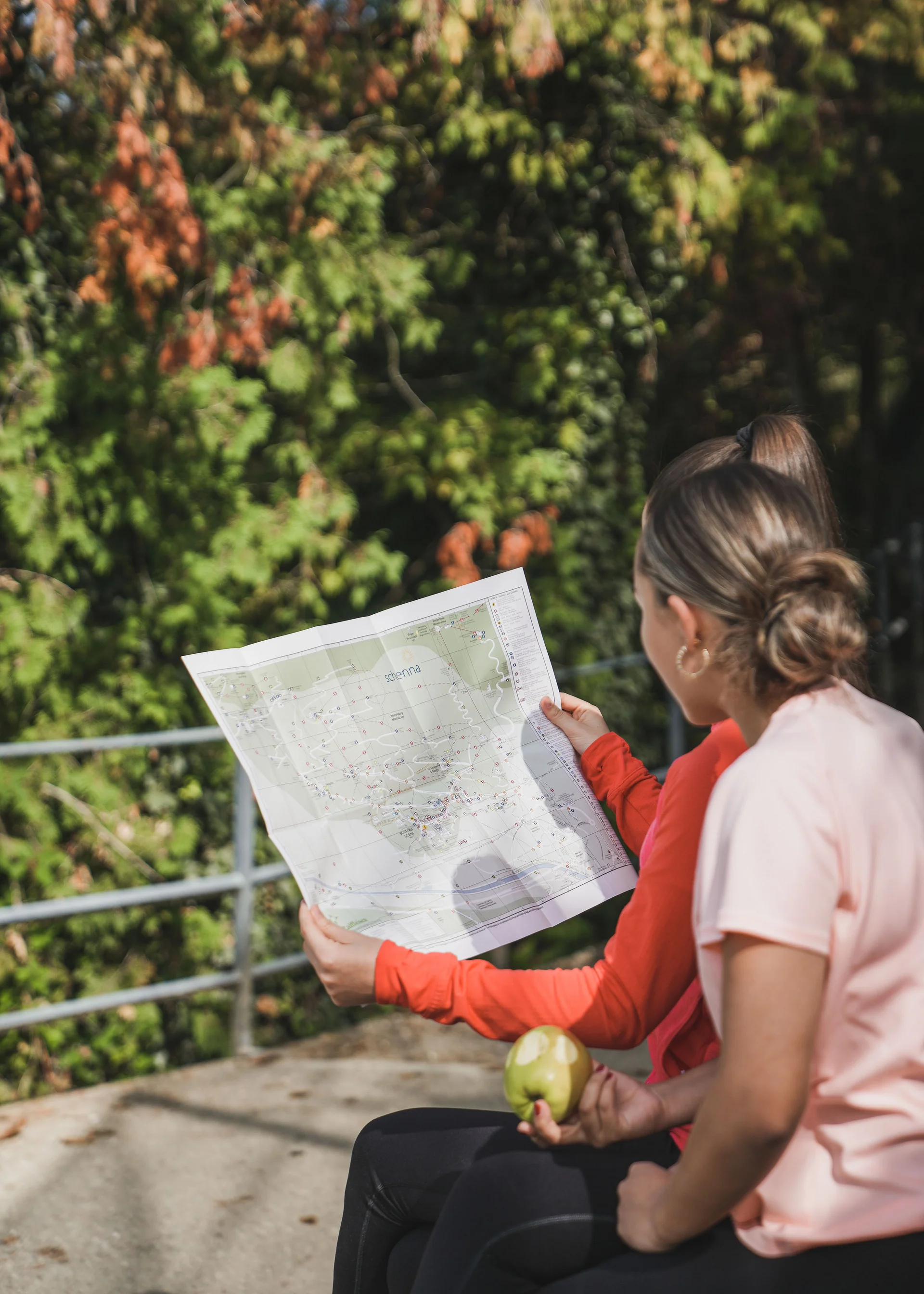 Echt regional: das Essen in eurem Genusshotel bei Meran Zwei Frauen sitzen draußen und schauen sich eine Landkarte an