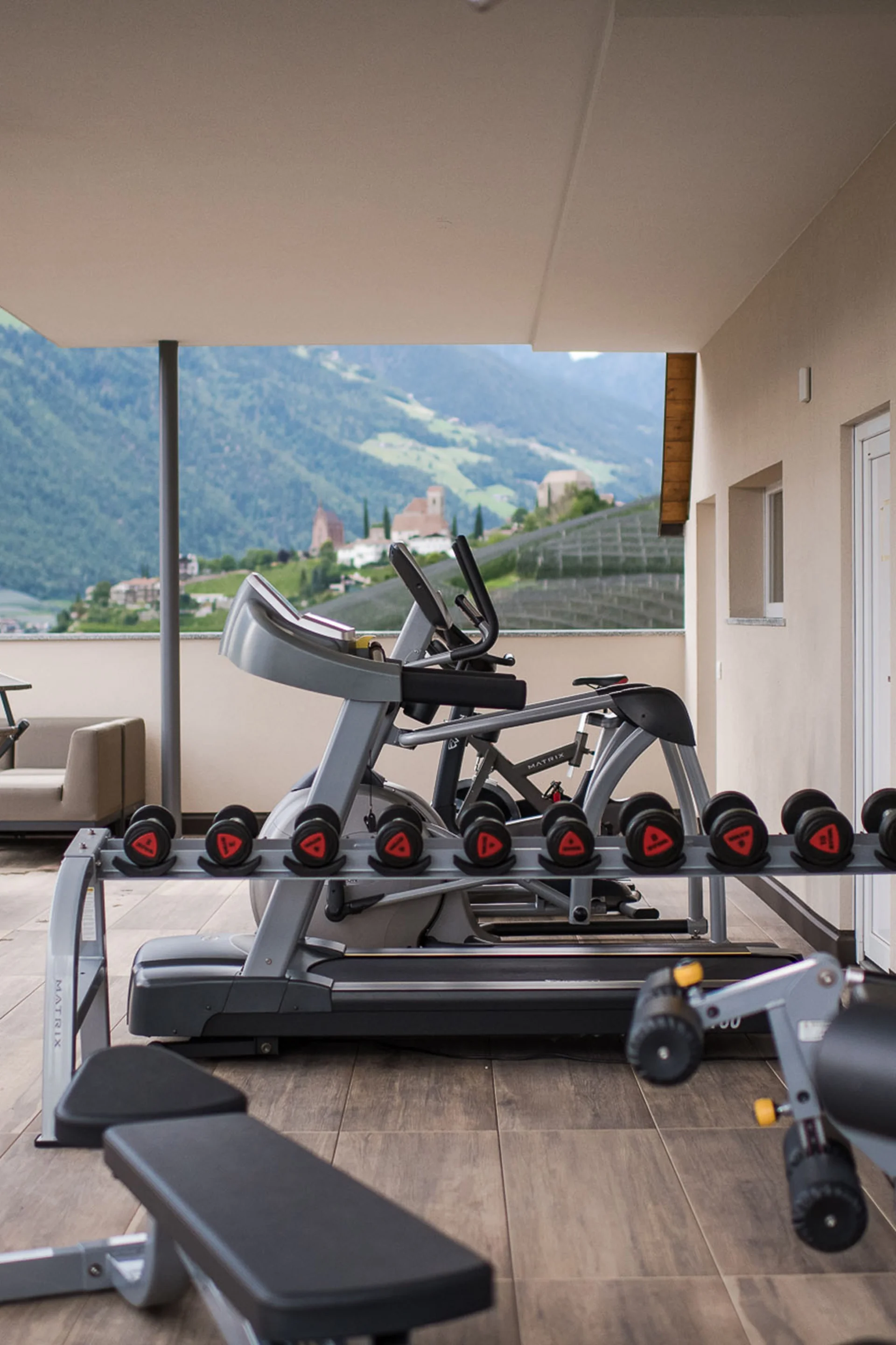 Outdoor-Fitnessstudio mit Geräten und Bergblick auf Terrasse