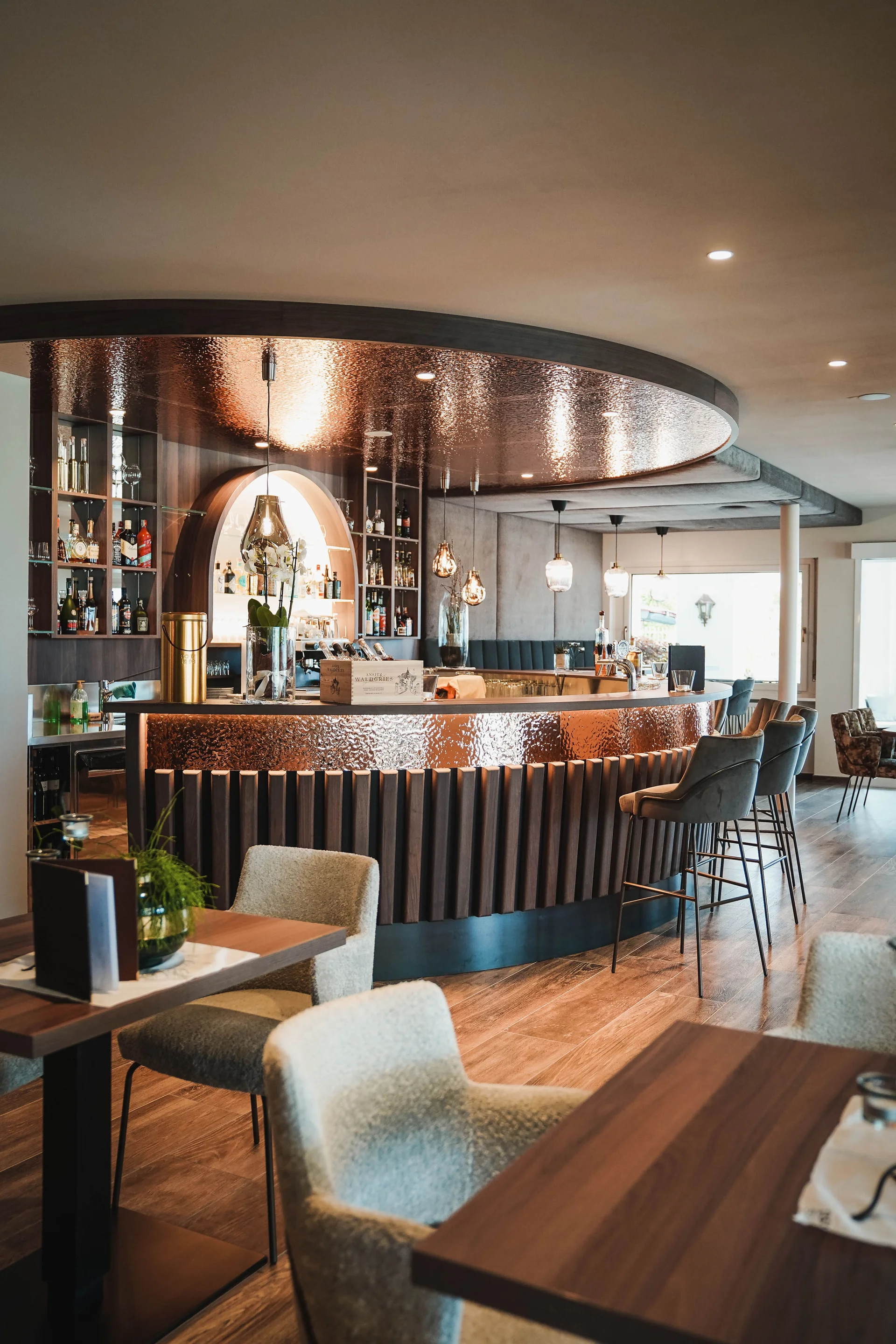 Das Herzstück des Kröll: unsere Bar und Lounge Moderner Restaurantinnenraum mit kupferfarbenem Barbereich und gemütlichen Sitzgelegenheiten