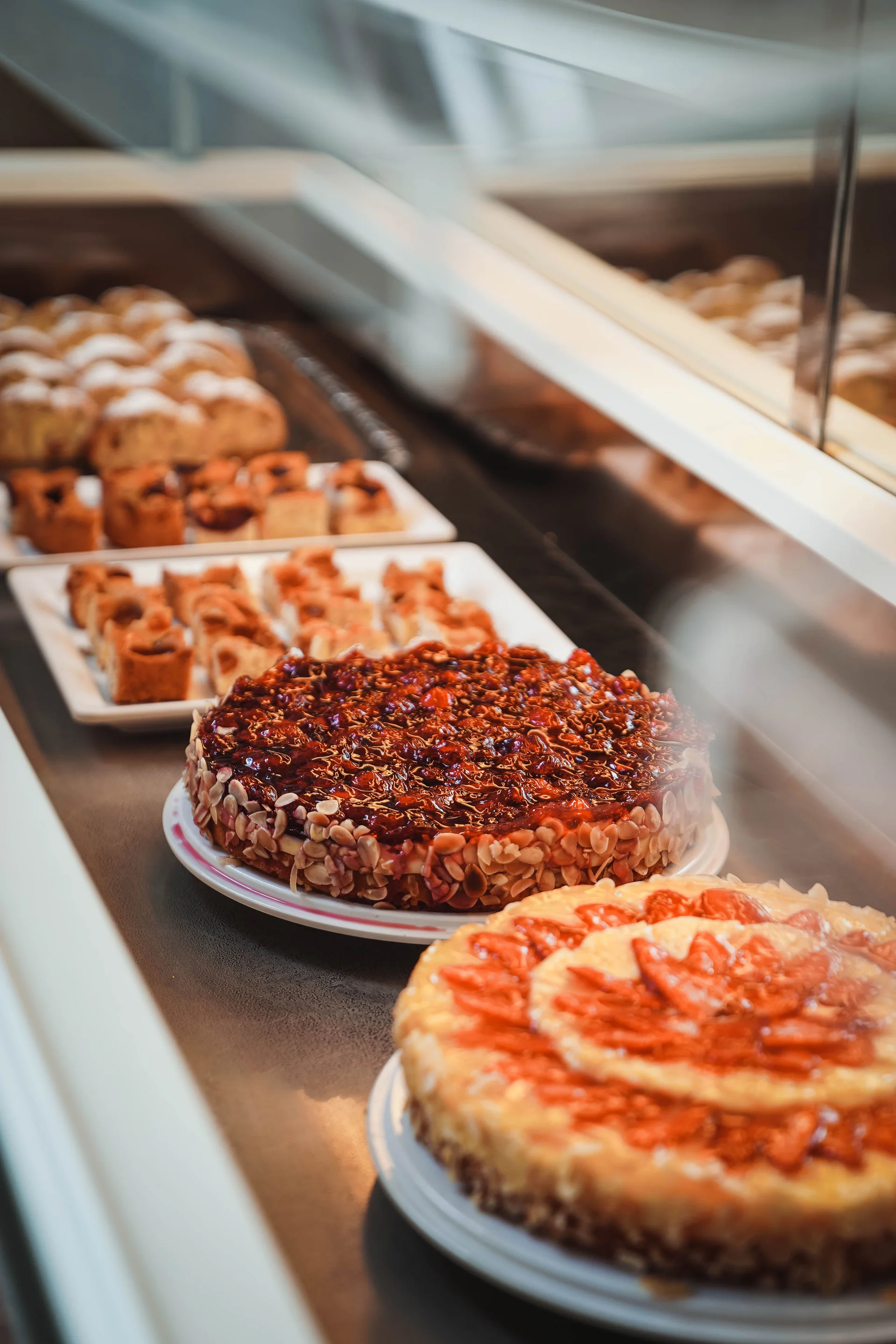 Echt regional: das Essen in eurem Genusshotel bei Meran Vitrine mit verschiedenen Torten und Gebäck in einer Bäckerei